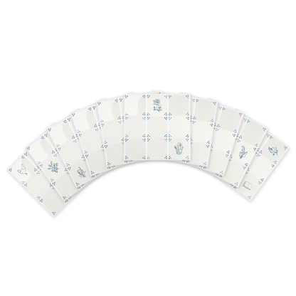 Ten Akka Home peel and stick Delft tiles fanned on white showing pre-printed motifs — chicken, tulips, lavender, peony and lily of the valley in Dutch Blue