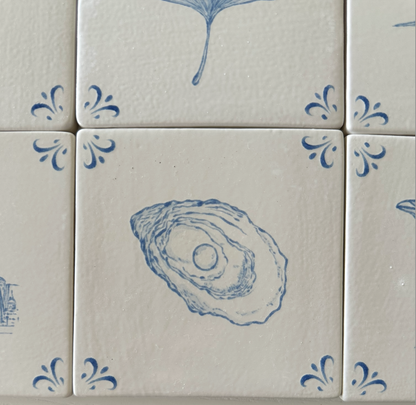 Close-up of the hand-painted oyster motif on an Akka Home Delft tile